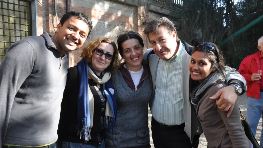 Small group of 16 travelers enjoying authentic cultural experience at Italian olive mill with local family